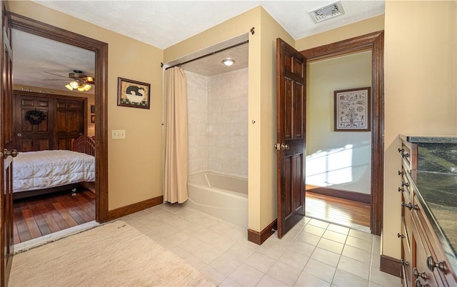 bathroom with ceiling fan, tile patterned floors, and shower / tub combo