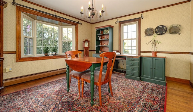 office space with crown molding, a baseboard heating unit, an inviting chandelier, and light wood-type flooring