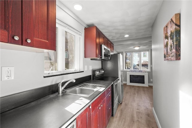 kitchen featuring stainless steel appliances, sink, and light wood-type flooring