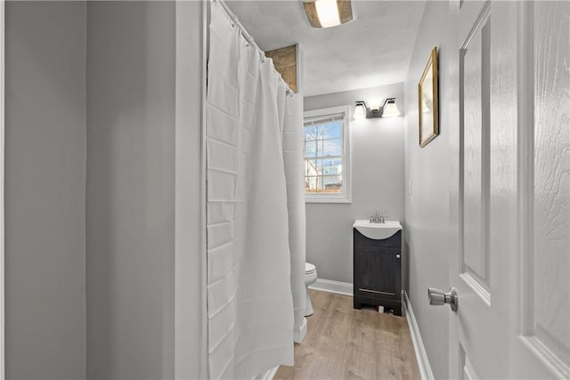 bathroom with hardwood / wood-style flooring, vanity, and toilet