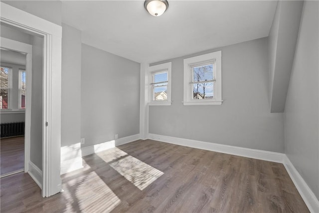 spare room featuring hardwood / wood-style flooring and radiator