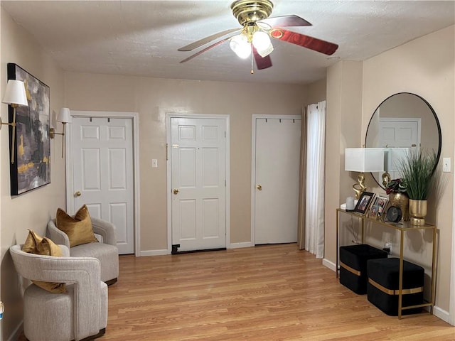 living area featuring ceiling fan and light hardwood / wood-style flooring