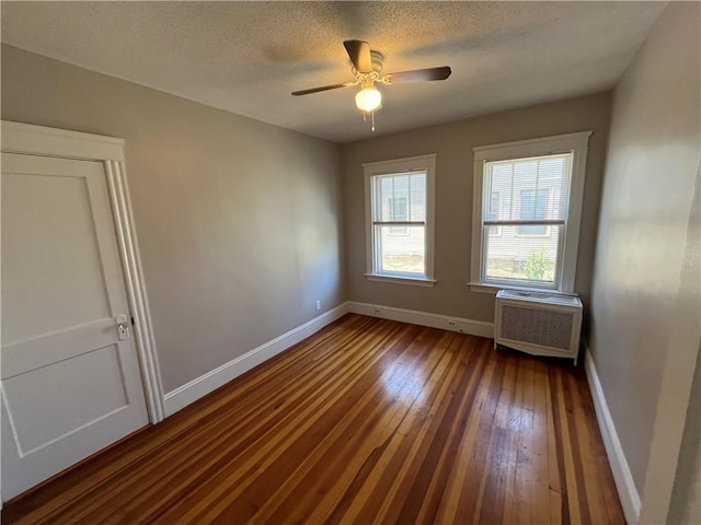 6 David St, East Providence, RI 02916 - spare room featuring baseboards, dark wood-type flooring, a ceiling fan, a textured ceiling, and radiator