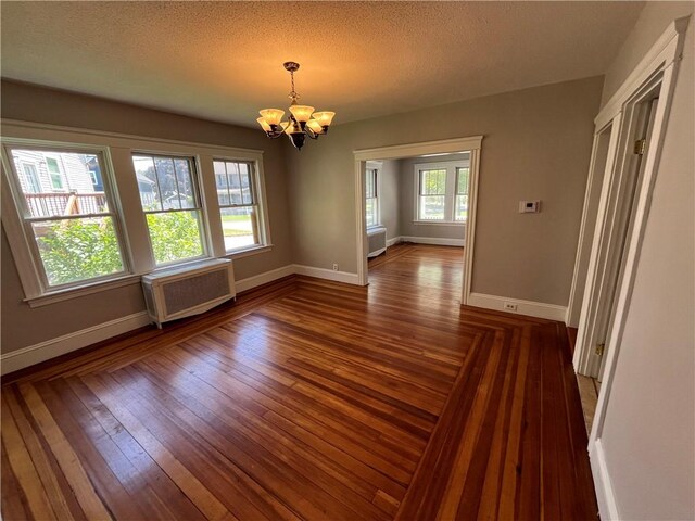 6 David St, East Providence, RI 02916 - unfurnished dining area featuring radiator heating unit, a chandelier, baseboards, wood-type flooring, and a textured ceiling
