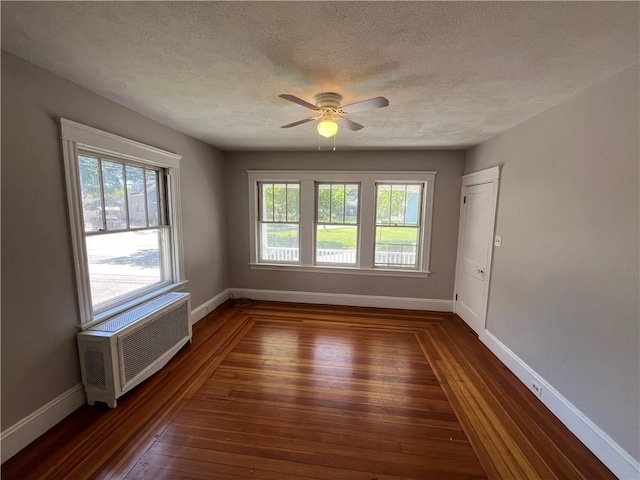 6 David St, East Providence, RI 02916 - empty room with plenty of natural light, ceiling fan, dark wood-style flooring, baseboards, and a textured ceiling