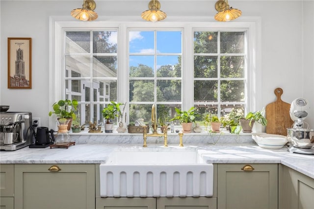 kitchen featuring gray cabinets, a healthy amount of sunlight, sink, and light stone counters