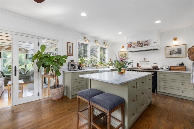 kitchen with crown molding, a center island, and dark wood-type flooring