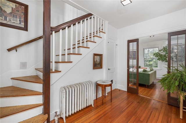 staircase with wood-type flooring and radiator