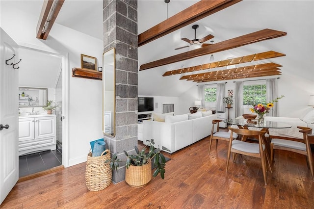 living room featuring hardwood / wood-style floors, vaulted ceiling with beams, sink, and ceiling fan