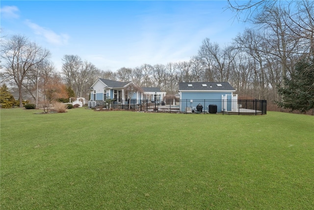 rear view of house with central AC unit and a lawn