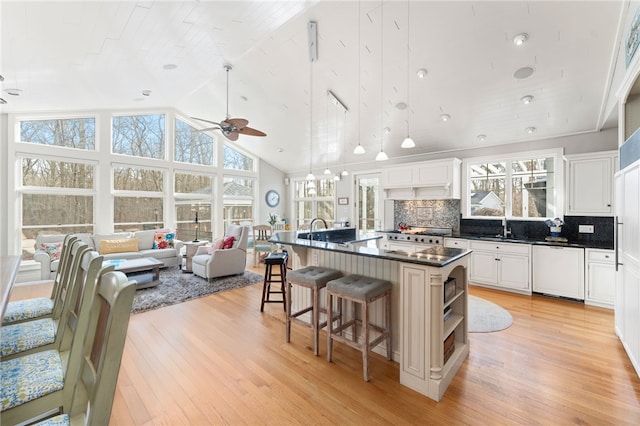 kitchen featuring sink, light hardwood / wood-style flooring, dishwasher, white cabinetry, and a kitchen island