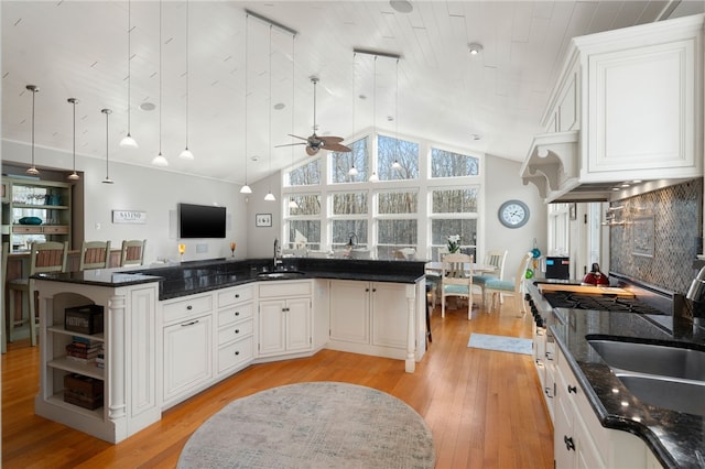 kitchen with white cabinetry, sink, light wood-type flooring, and a kitchen island