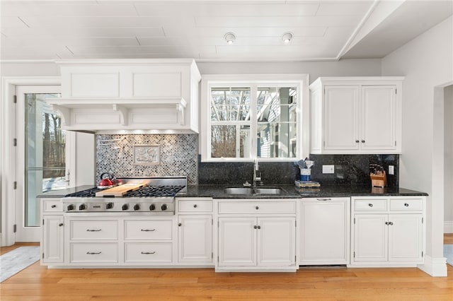 kitchen featuring white cabinetry, sink, dark stone countertops, and stainless steel gas cooktop