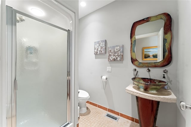 bathroom with sink, tile patterned floors, toilet, and walk in shower