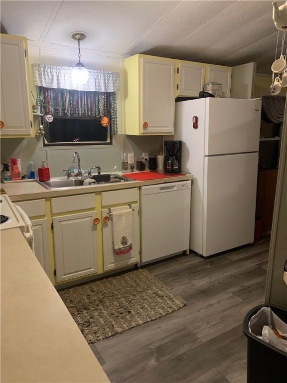 kitchen featuring hanging light fixtures, dark hardwood / wood-style flooring, sink, and white appliances