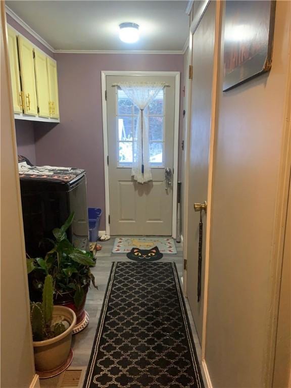 doorway to outside featuring crown molding and washer / dryer