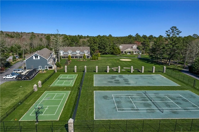 view of property's community with a yard and tennis court