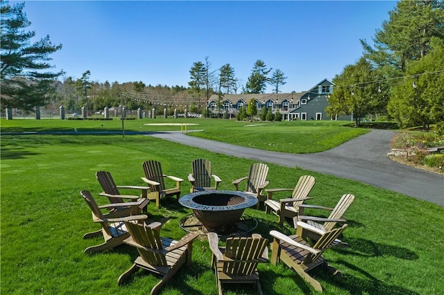 surrounding community with a yard and a fire pit