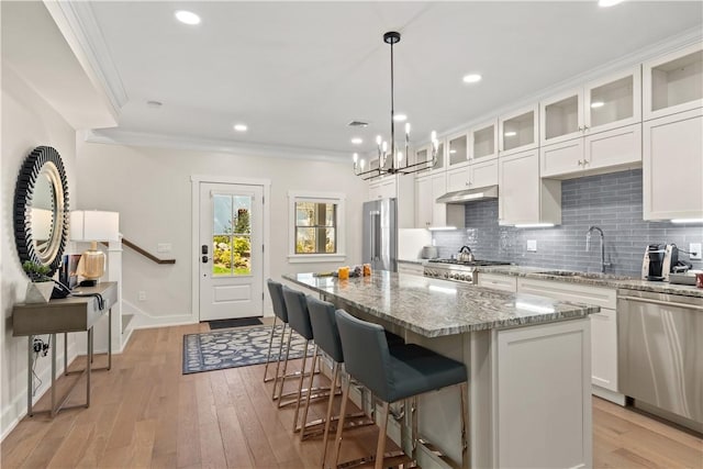 kitchen featuring sink, crown molding, white cabinetry, stainless steel appliances, and a kitchen island