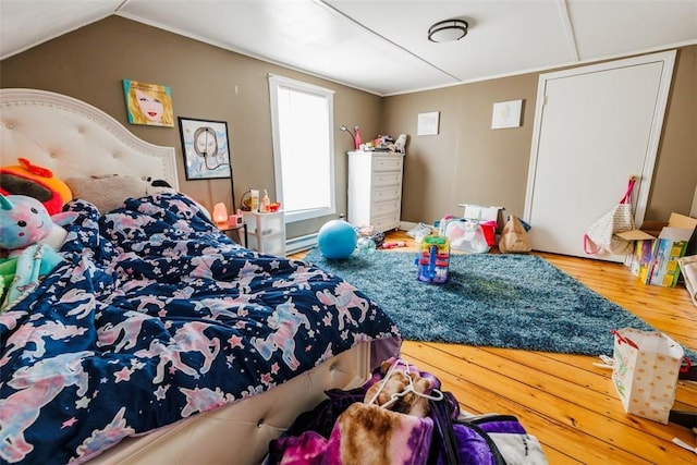 bedroom featuring wood-type flooring, lofted ceiling, and baseboard heating