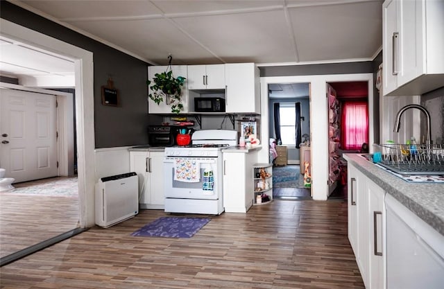 kitchen with sink, gas range gas stove, white cabinetry, ornamental molding, and light wood-type flooring