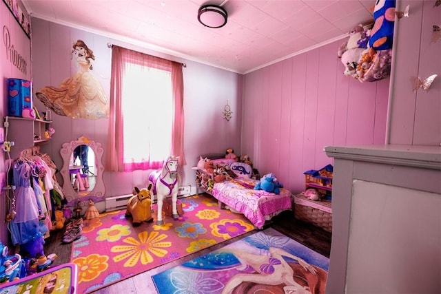 bedroom featuring a baseboard heating unit, hardwood / wood-style flooring, and ornamental molding