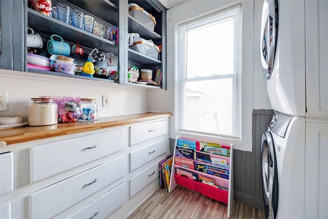 interior space featuring stacked washer and dryer and light hardwood / wood-style flooring