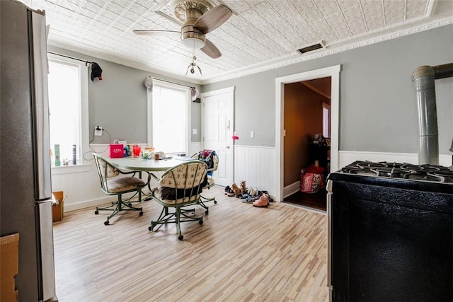 dining room featuring crown molding, light hardwood / wood-style floors, and ceiling fan