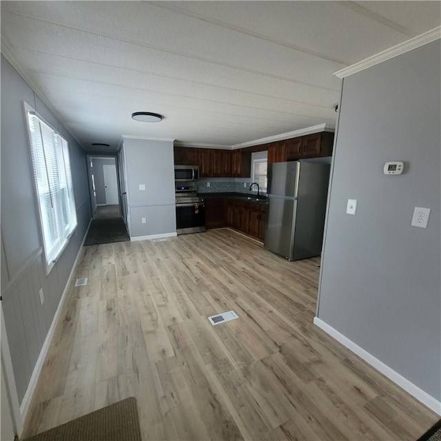 kitchen featuring sink, dark brown cabinetry, light hardwood / wood-style floors, stainless steel appliances, and crown molding