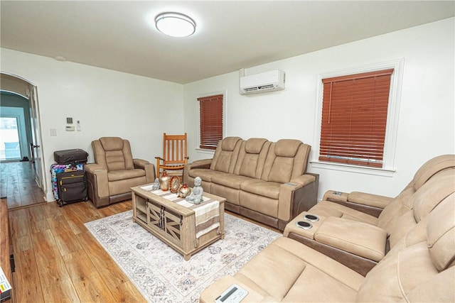 living room featuring hardwood / wood-style flooring and a wall mounted air conditioner