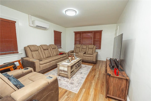 living room featuring an AC wall unit and light hardwood / wood-style floors