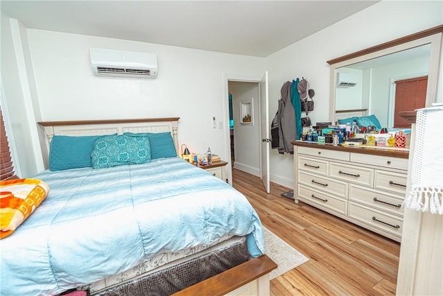 bedroom featuring light hardwood / wood-style flooring and an AC wall unit