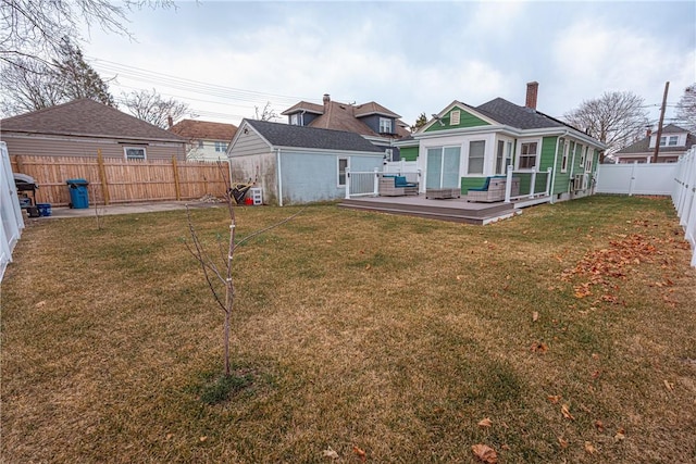 rear view of house with a wooden deck and a lawn