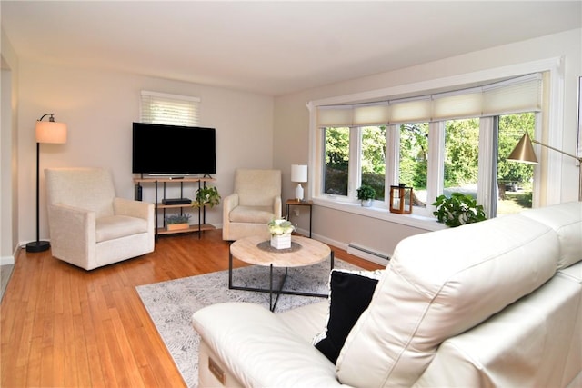 living room with baseboard heating and light hardwood / wood-style flooring