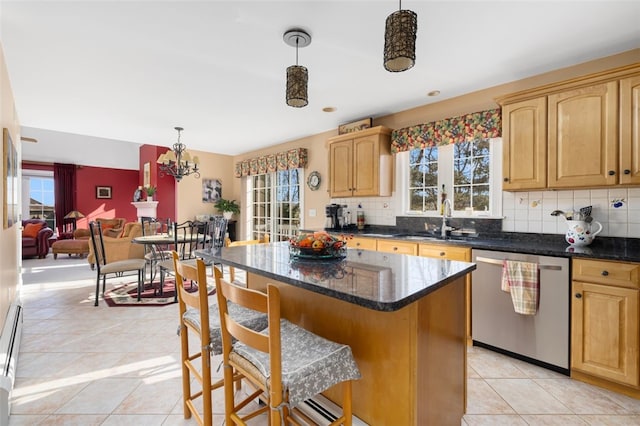 kitchen with pendant lighting, sink, dishwasher, backsplash, and a center island