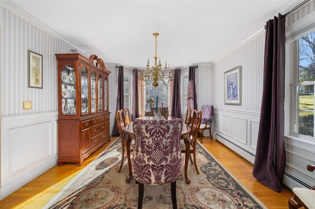 dining room with an inviting chandelier, a healthy amount of sunlight, crown molding, and light hardwood / wood-style floors