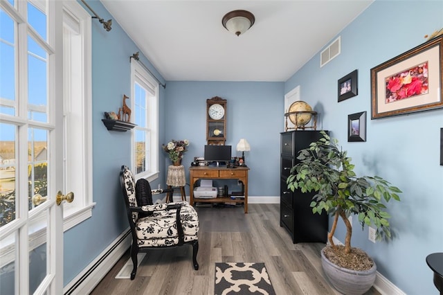 sitting room with baseboard heating and hardwood / wood-style floors