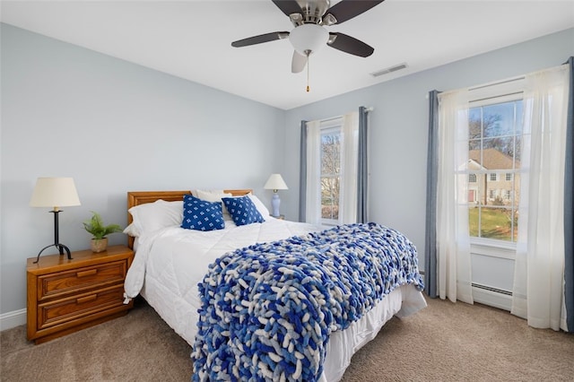 carpeted bedroom with ceiling fan and a baseboard radiator