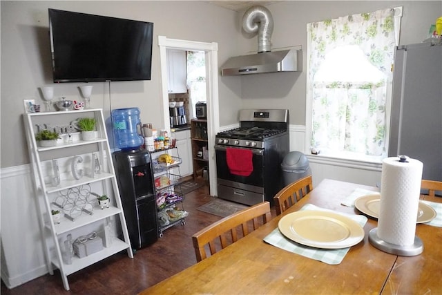 kitchen with dark wood-type flooring, stainless steel appliances, and wall chimney exhaust hood