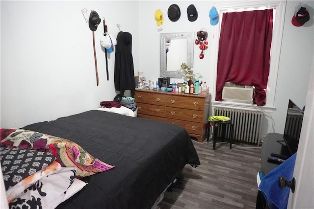 bedroom with radiator heating unit, dark hardwood / wood-style flooring, and cooling unit