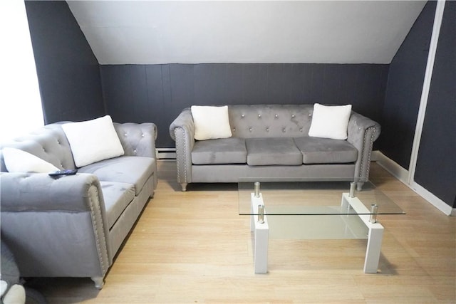 living room featuring a baseboard heating unit, vaulted ceiling, and light hardwood / wood-style floors