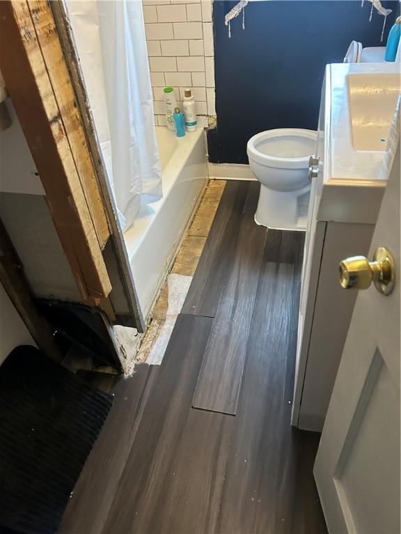 full bathroom with hardwood / wood-style flooring, vanity, toilet, and shower / bath combo