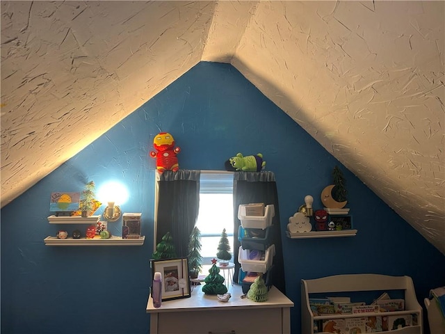 bedroom with vaulted ceiling and a textured ceiling