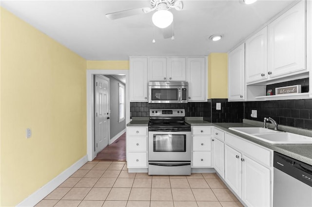 kitchen featuring sink, light tile patterned floors, white cabinets, and appliances with stainless steel finishes