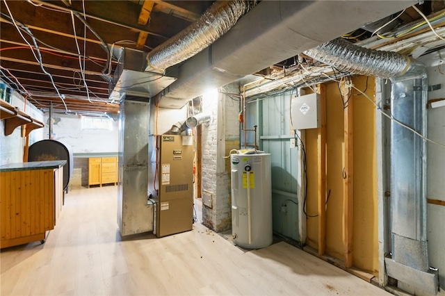 basement with electric water heater, heating unit, and light hardwood / wood-style floors