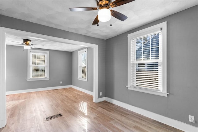 spare room with ceiling fan and light wood-type flooring