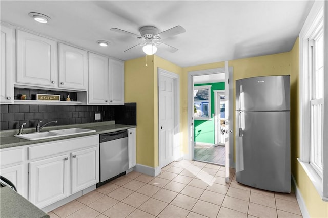 kitchen featuring white cabinetry, sink, decorative backsplash, light tile patterned floors, and stainless steel appliances