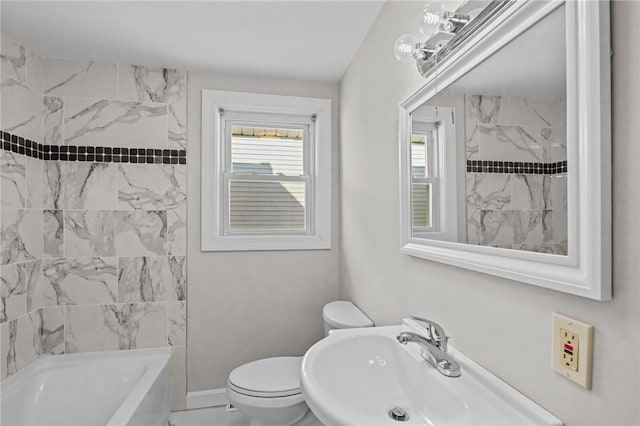 full bathroom featuring tiled shower / bath, sink, and toilet