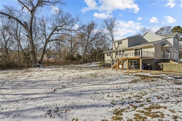 snowy yard featuring a wooden deck