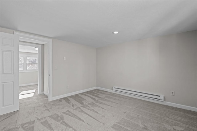 unfurnished room with a baseboard radiator and light colored carpet